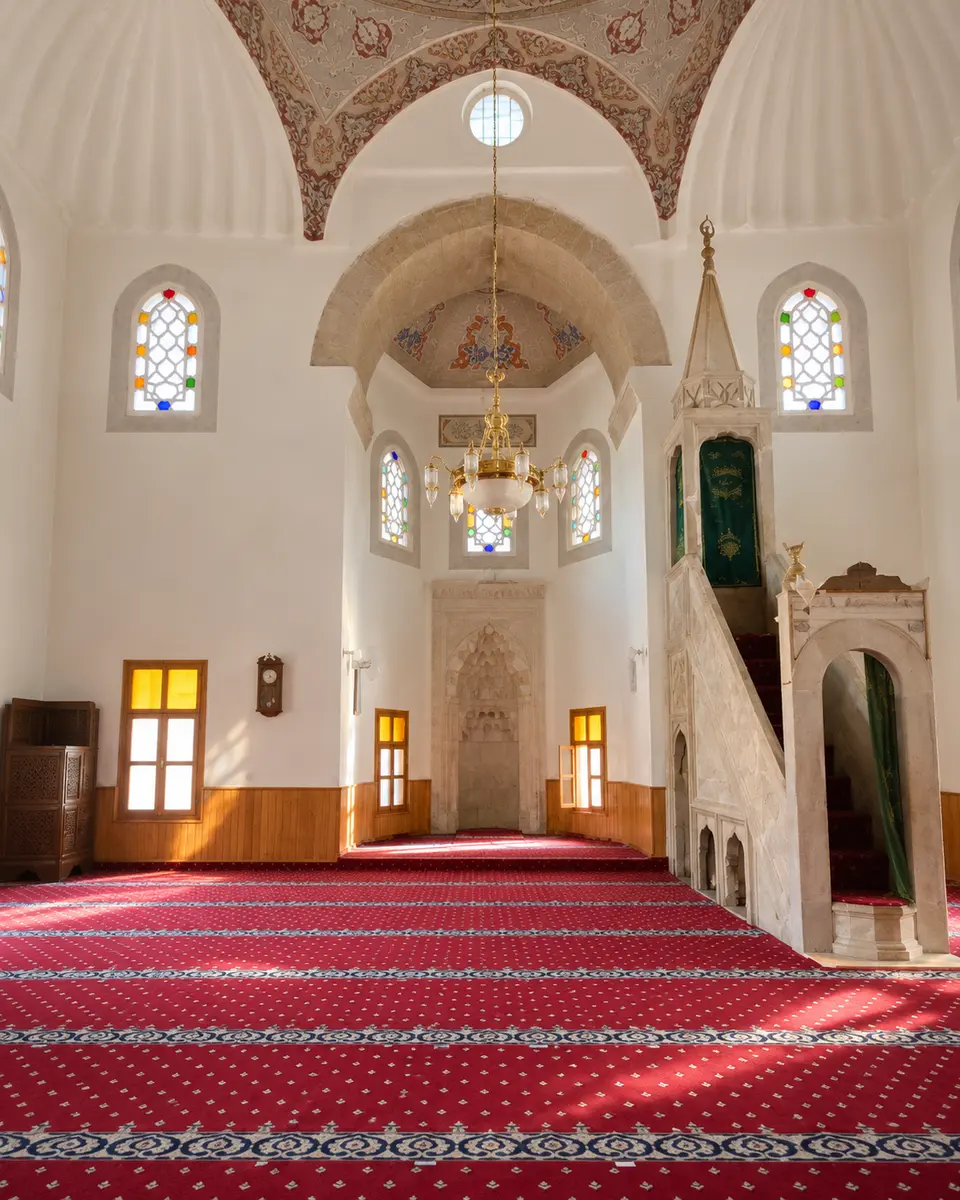 Red-carpeted interior, mihrab and minbar of the Yakup Ağa Mosque — representative image